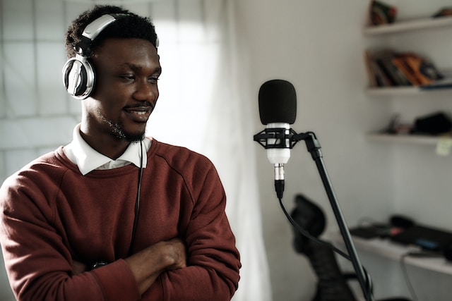 Man wearing headphones standing near a microphone