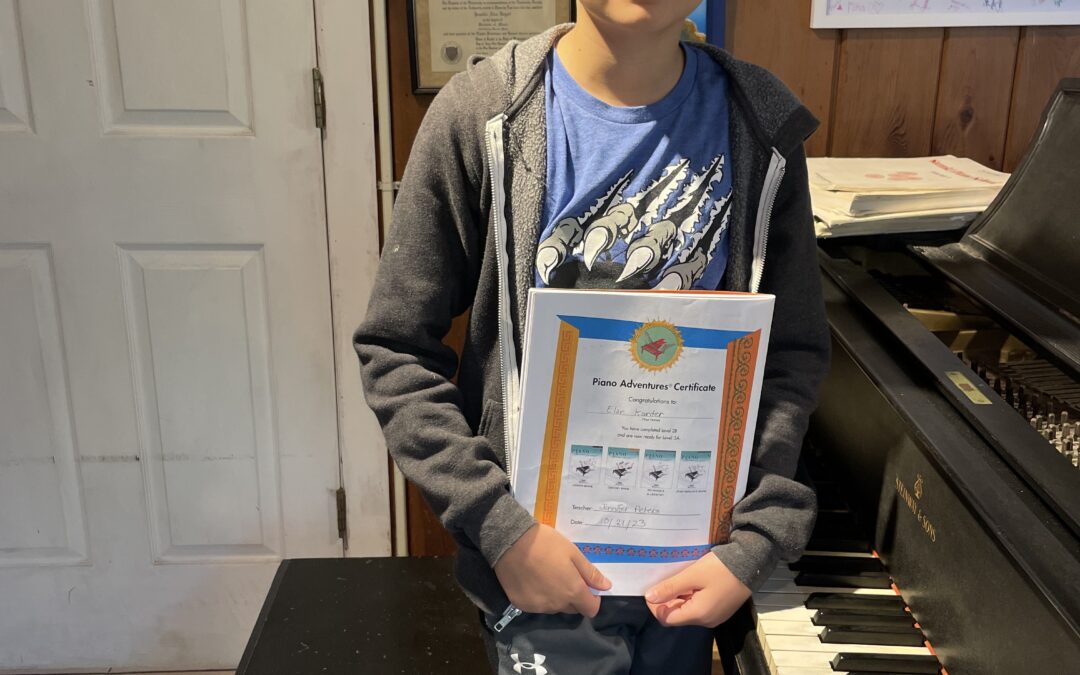 Boy holding piano certificate