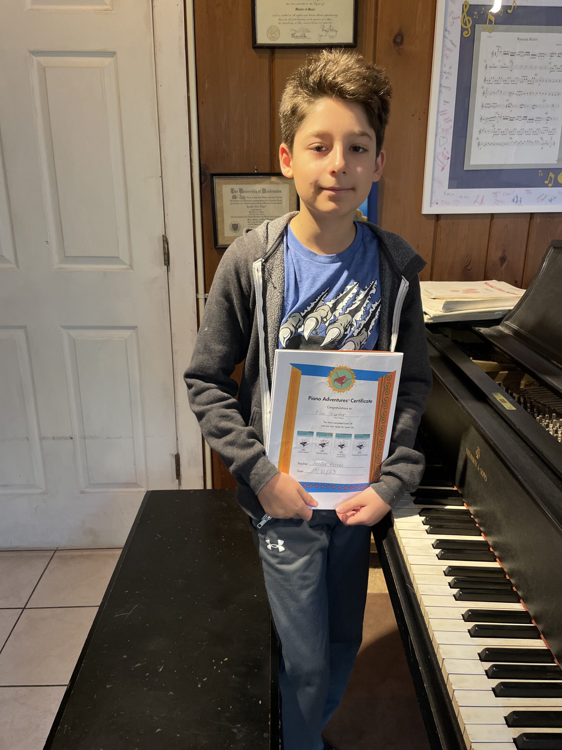 Boy holding piano certificate
