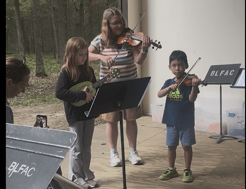 Ukulele and fiddle jam with children